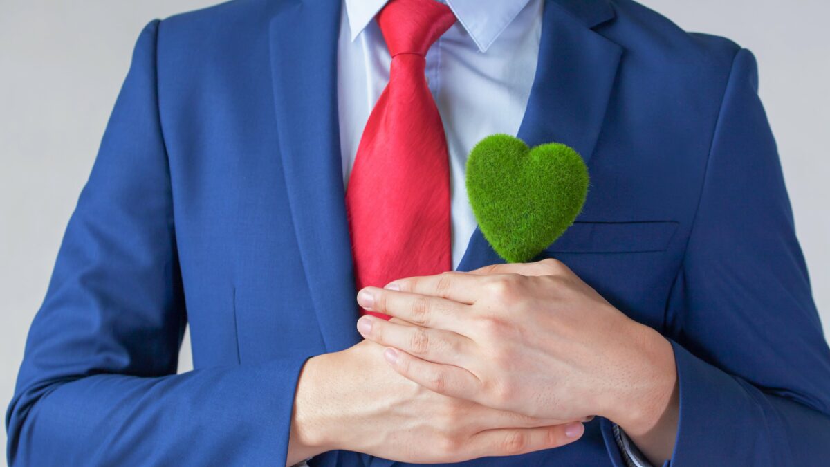 Businessman holding a green heart.