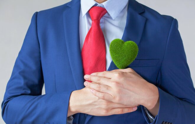 Businessman holding a green heart.