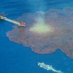 Air photo of oil leaking into the sea around an oil platform.