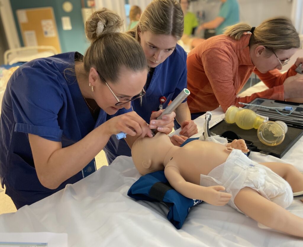 Studenter øver på praktiske ferdigheter på babydukke.