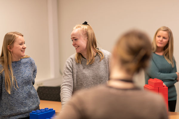 Studenter jobber med store legoklosser i matematikkfaget. Foto