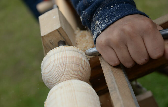 Hånd som lager trekule med verktøy. Foto