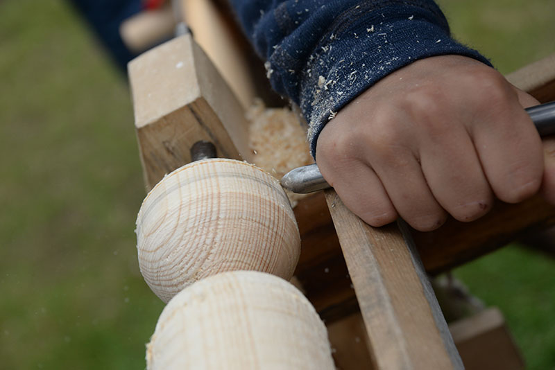 Hånd som lager trekule med verktøy. Foto