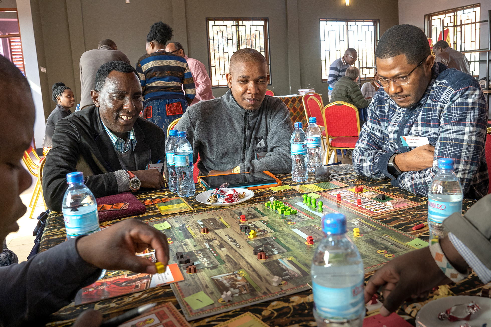A group of people in Tanzania playing the Savanna Life board game. Photo