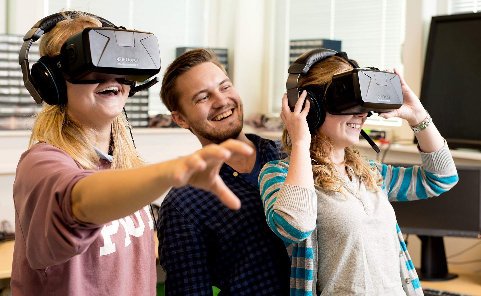 To studenter so ser gjennom VR-briller sammen med veileder. Foto