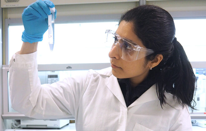 Sharada Navada examining a sample in the lab. Photo