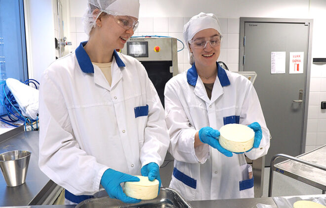To studenter på lab som holder en ost i hånden. Foto