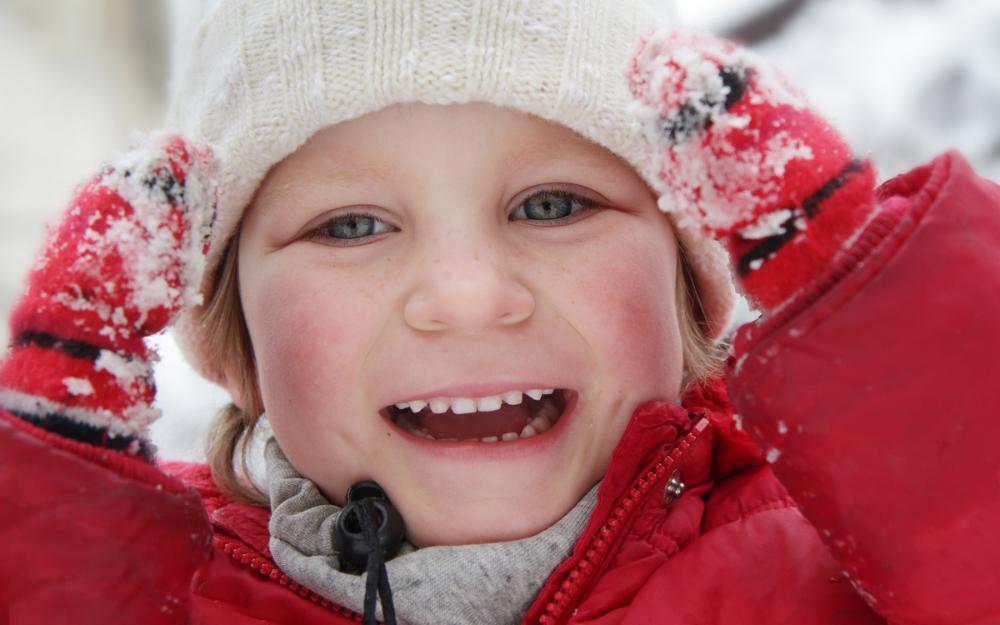 Jente i femårsalderen leker i snøen. 