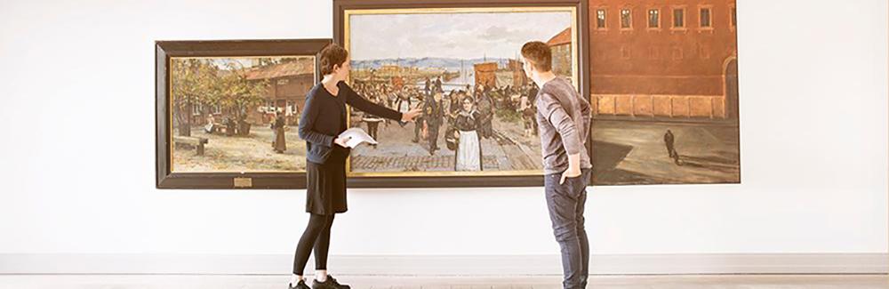 Personer betrakter billedkunst på museum. Foto