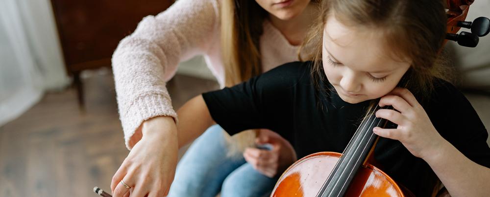 Jente lærer å spille cello. Foto