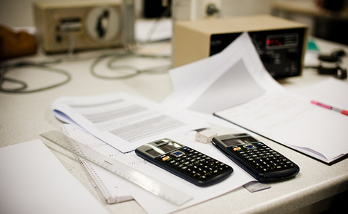 Kalkulatorer på et skrivebord med papirer og elektronisk utstyr/FOTO