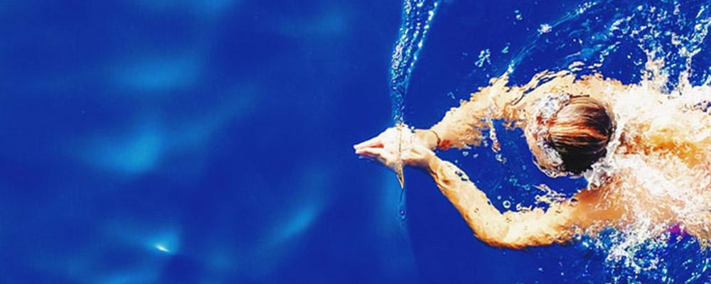 Illustrasjonbilde av en kvinne som svømmer delvis under vann