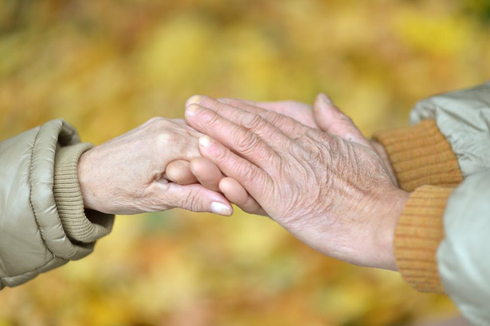 Eldre par holder hender. Foto.