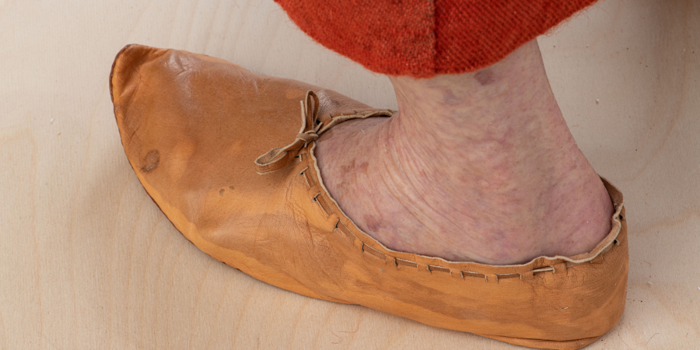 Nærbilde av foten til en middelalderkvinne, med skinnsko