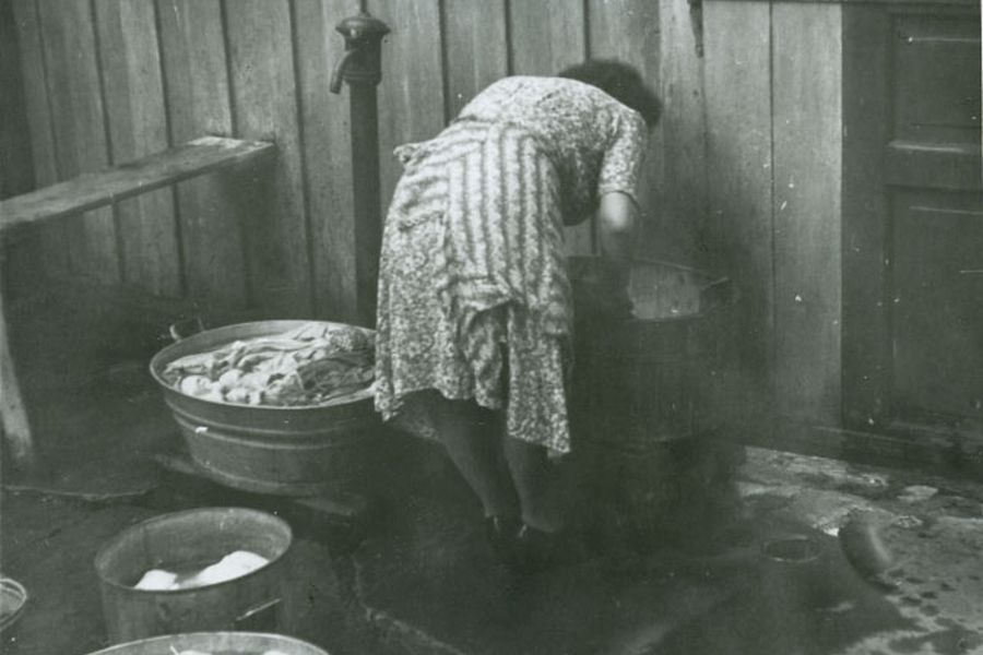 Kvinne vasker klær i bakgård i Trondheim, tidlig 1950-tall.