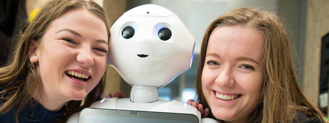 To kvinnelige studenter med roboten Pepper