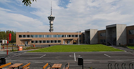 Skolebygning med Tyholttårnet i bakgrunnen. Foto