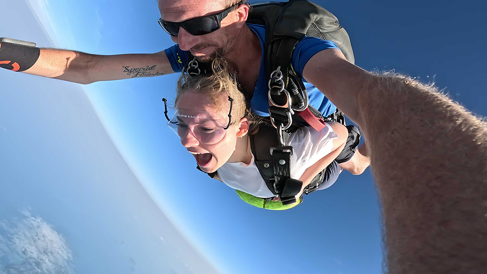 To mennesker hopper fallskjerm. Foto