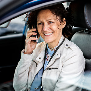 Smilende kvinne som prater i mobiltelefon