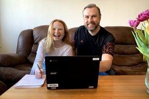Far og datter i sofaen foran laptop