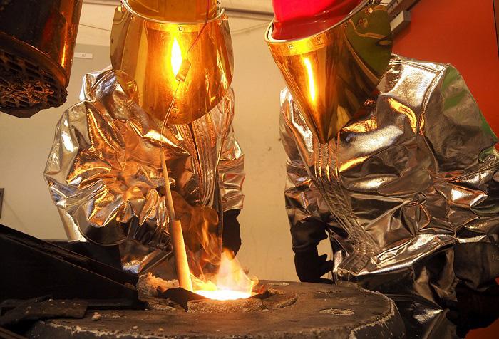 To forskere som smelter metall. Foto