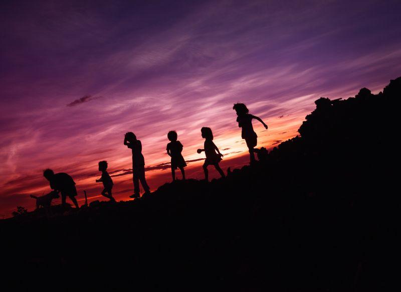 Barn i silhuett i solnedgangen. Foto