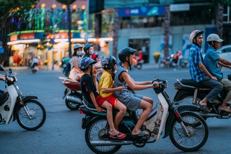 Tre barn på moped. Foto