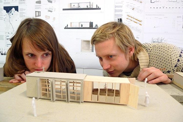 To studenter kikker inn i en bygningsmodell