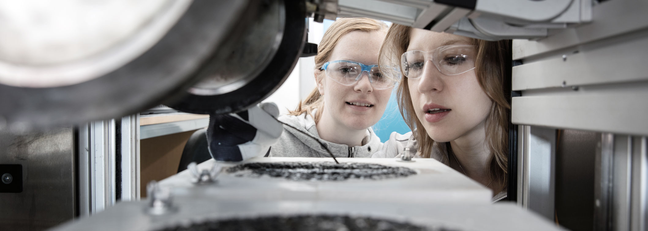 To kvinnelige forskere studerer asfaltprøve i lab. Foto