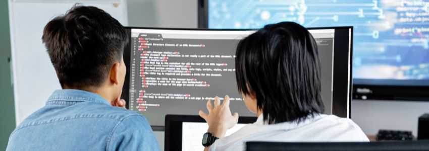 To ungdommer sitter foran en PC og jobber med koding. Foto