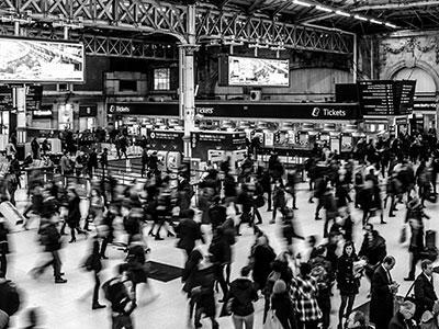 Mennesker går på en togstasjon. Foto: Pexels