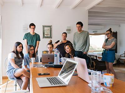 En gruppe personer ser på en laptop. Foto: Pexels.