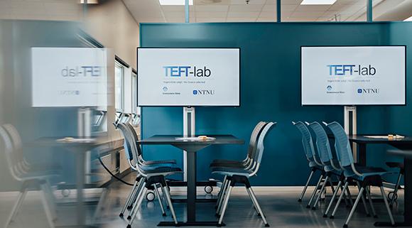 Blå stoler mot blå bakgrunn med Teft-logo. Foto.
