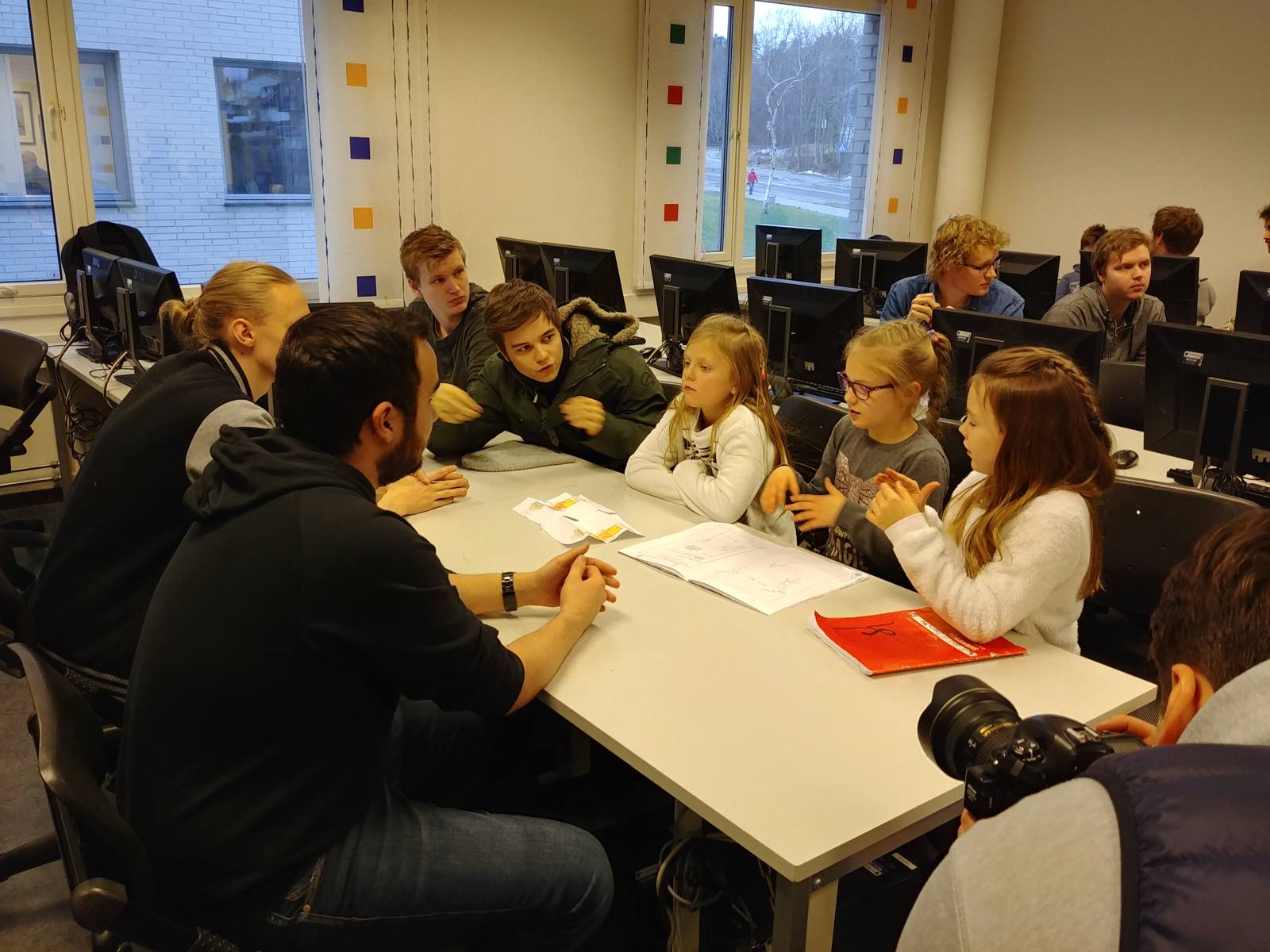 Foto: Skolebarn som kunder i diskusjon med en gruppe studenter