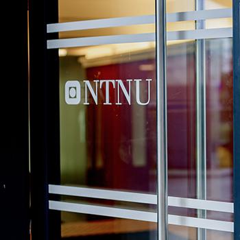Glassdør med NTNU-logo. Foto.