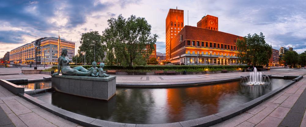 Oslo rådhus med vannspeil i forgrunnen. Foto.