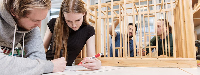 Byggstudenter jobber med byggtegninger og bygger modell i laboratoriet