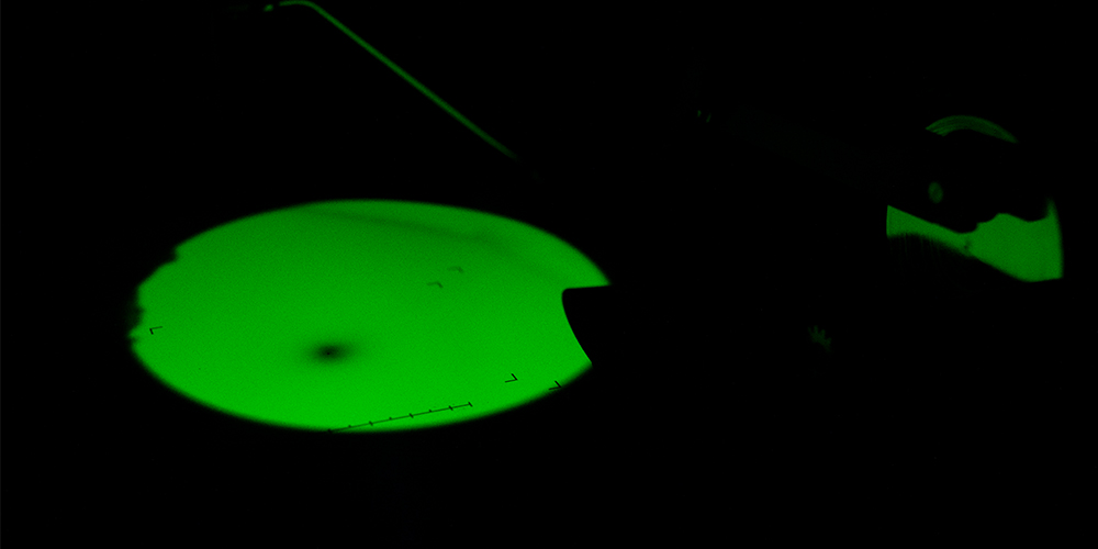 Grønn modell i mikroskop. Foto