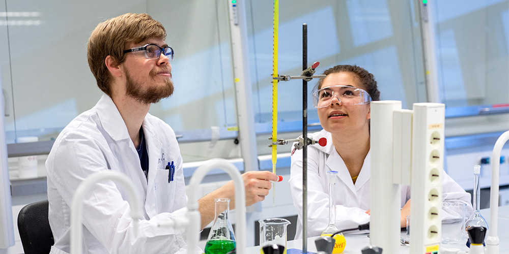 To studenter utfører titrering på lab. Foto