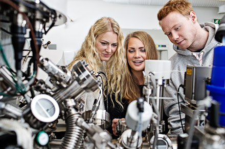 Tre studenter står ved utsyr for å lage nye elektroniske materialer. Bilde  Foto: Geir Mogen