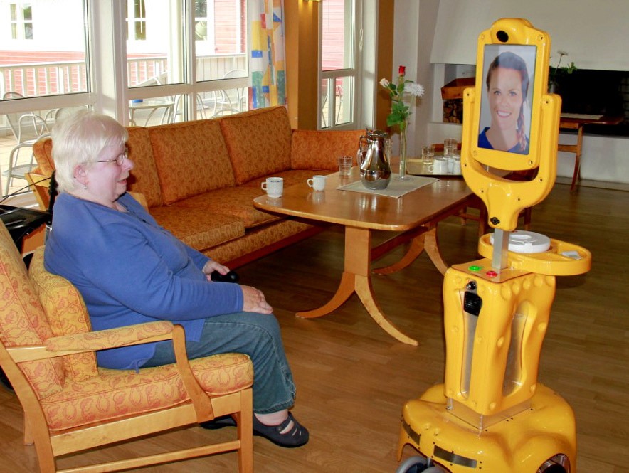 Eldre kvinne som snakker med person avbildet på en skjerm. 