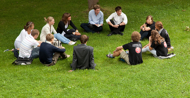 Studenter sitter i en ring på ei plen. Foto: Kai Dragland